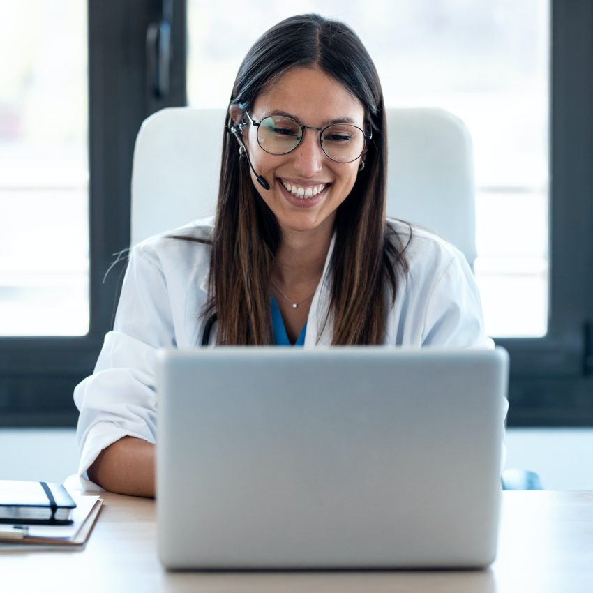 female-doctor-talking-with-colleagues-through-a-video-call-with-a-laptop-in-the-consultation-1-2.jpg